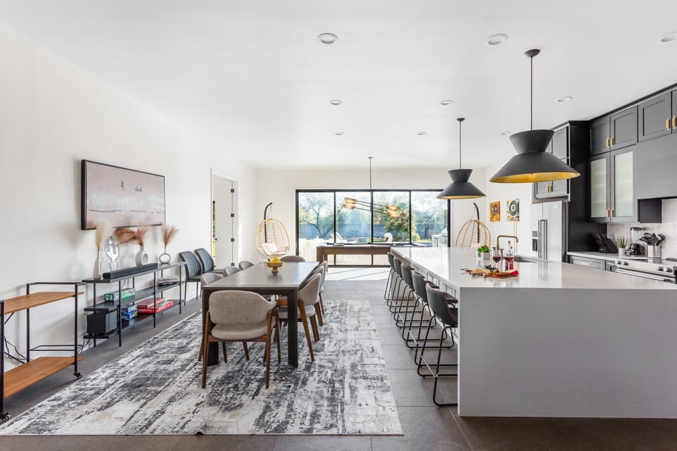 Fully Equipped Kitchen featuring stainless-steel appliances, a kitchen island with seating for 5 guests, a dining table with seating for 8 guests and a pool table.