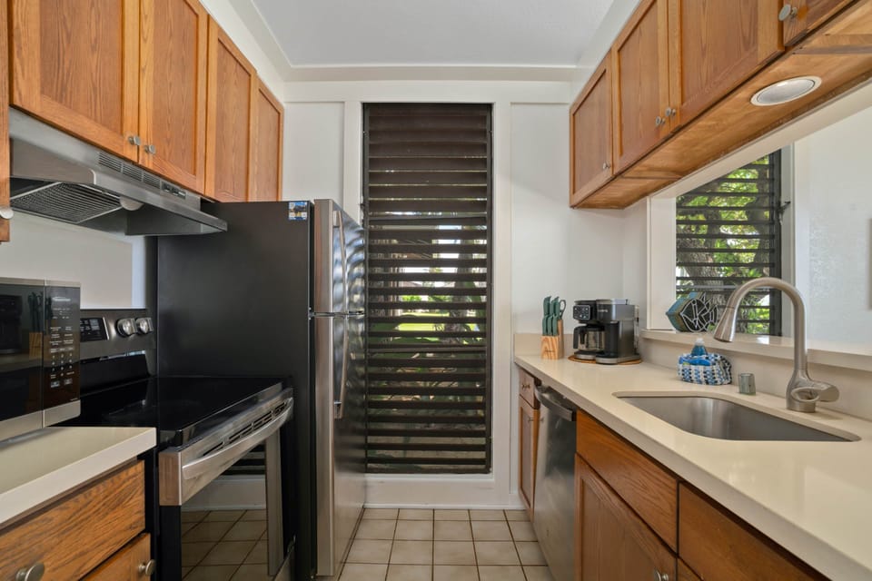 Fully equipped kitchen with modern appliances and island-inspired charm — everything you need to coo