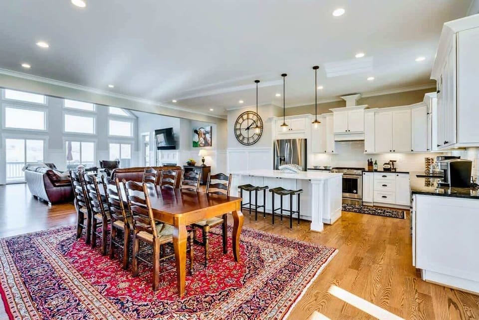 Open-concept kitchen and dining area with a large wooden table, modern appliances, and ample natural light
