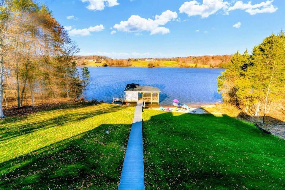 Picturesque pathway leading down to a private dock and sandy beach area on a serene lake