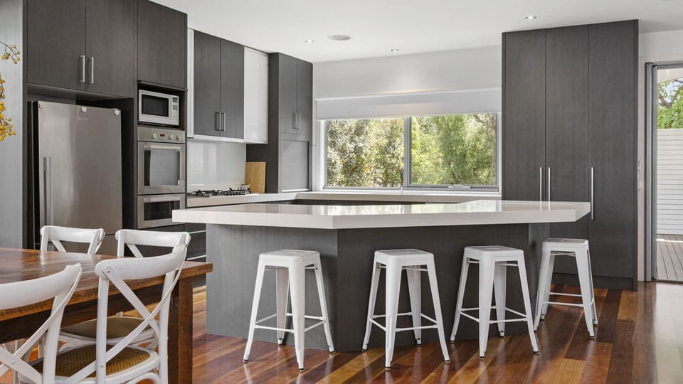 Fully equipped kitchen with stone bench tops and stainless steel appliances
