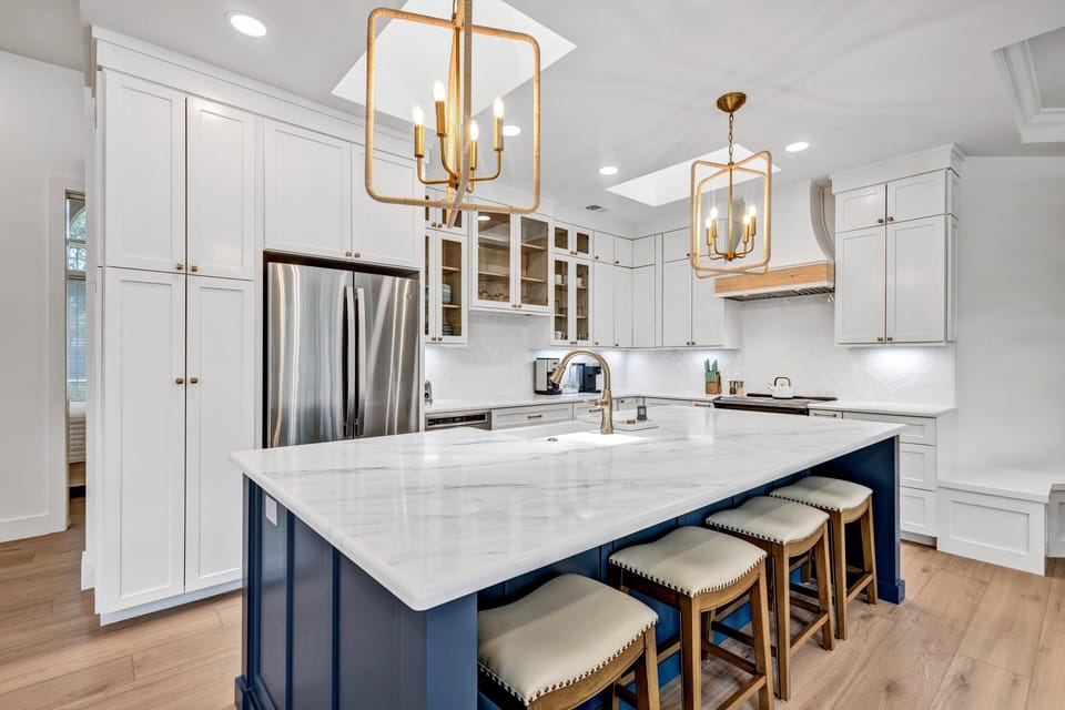 A chef's kitchen with bar stool seating and formal dining areas.