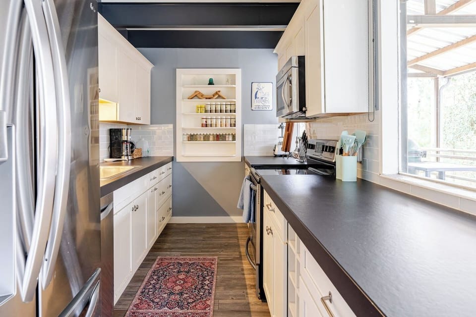 stove, dishwasher, oven, microwave, coffee maker, pots, pans, plates, bowls, cups