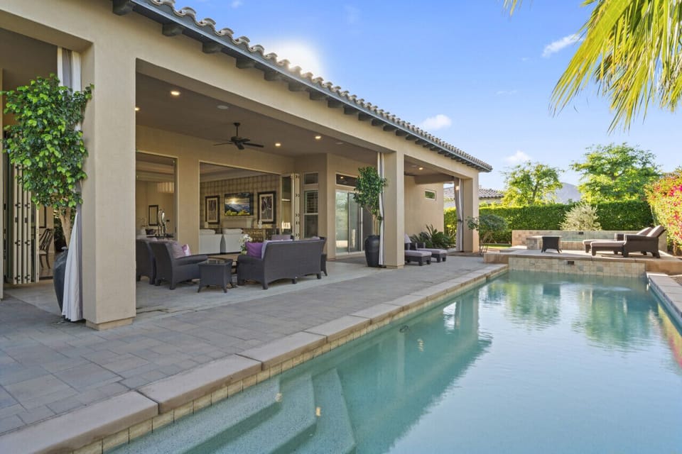 Backyard pool alongside a covered patio w/ seating for relaxing in the shade