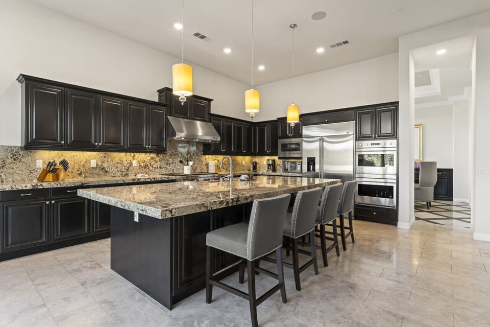 Spacious kitchen w/ large island, bar seating & dark cabinetry for easy meal prep