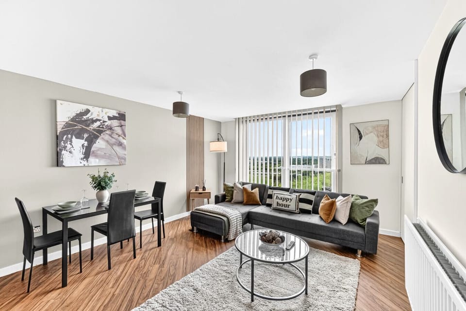 A spacious living room featuring a comfortable corner sofa and a 55-inch Smart TV, complete with Sky and Netflix subscriptions for your entertainment.