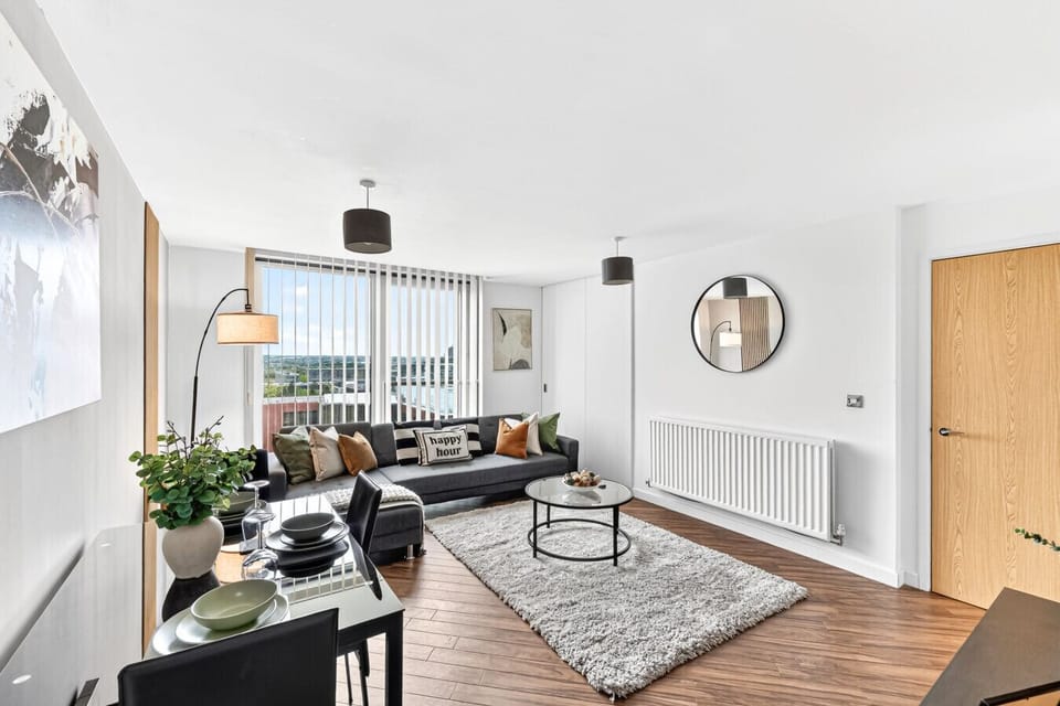 A spacious living room featuring a comfortable corner sofa and a 55-inch Smart TV, complete with Sky and Netflix subscriptions for your entertainment.