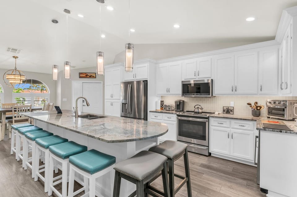 Kitchen is fully stocked with stainless steel appliances, pots, dishes, utensils