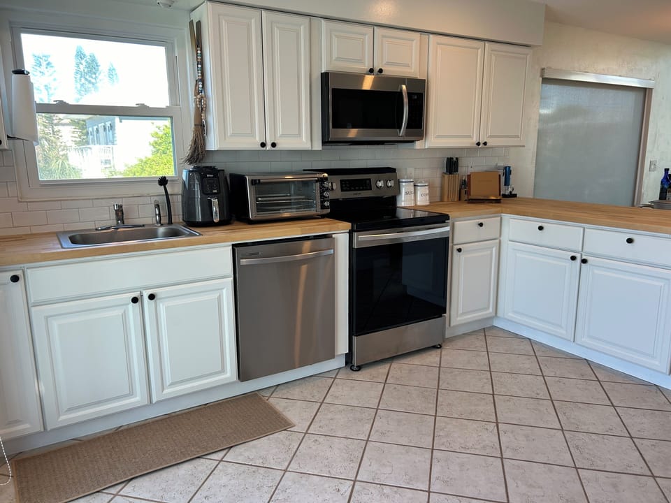 kitchen is fully-stocked with appliances, dishes, pots/pans and cooking utensils