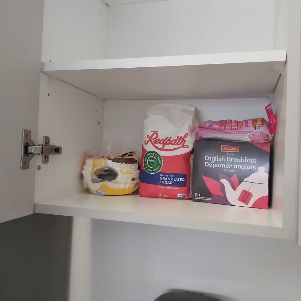 Pantry stocked with sugar, English Breakfast tea, and snacks for your comfort