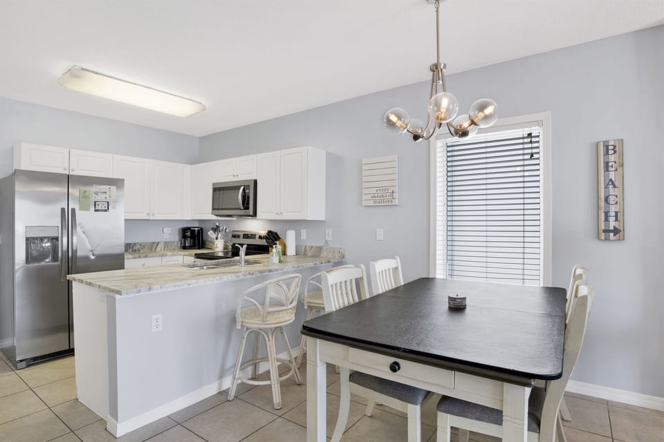 Dining area with table and 4 chairs and additional bar seating