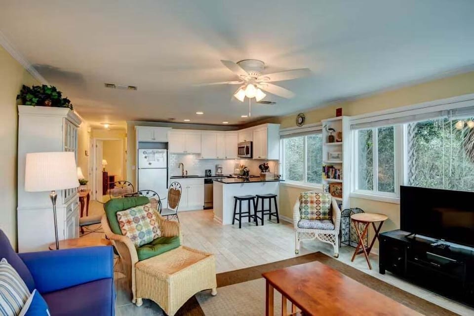 Open concept living area with stylish furnishings balcony access TV
