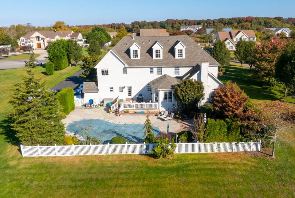 Drone view of rear of home with pool