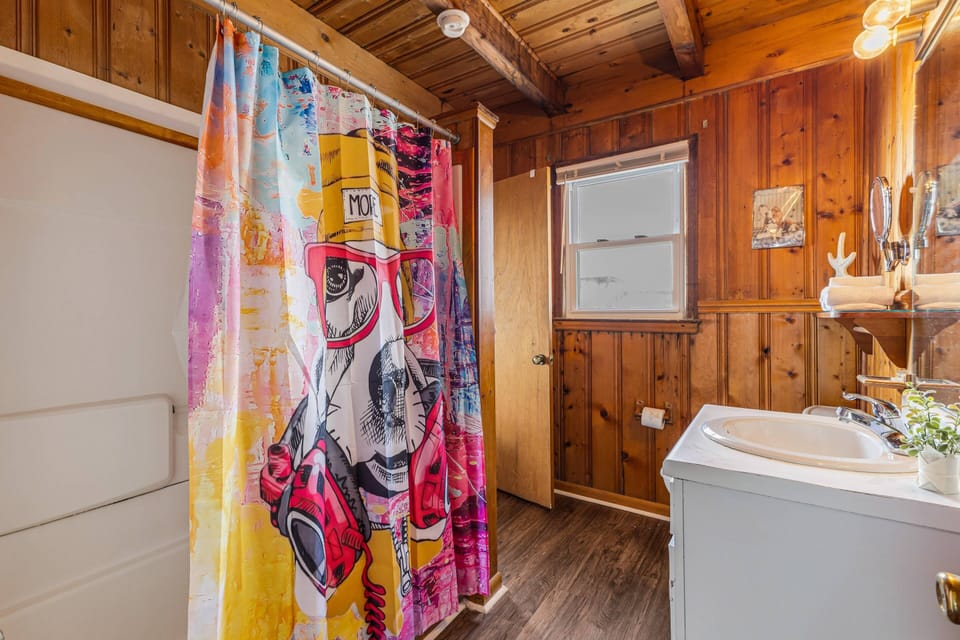 This vibrant bathroom features a shower, a sink and a vanity mirror.