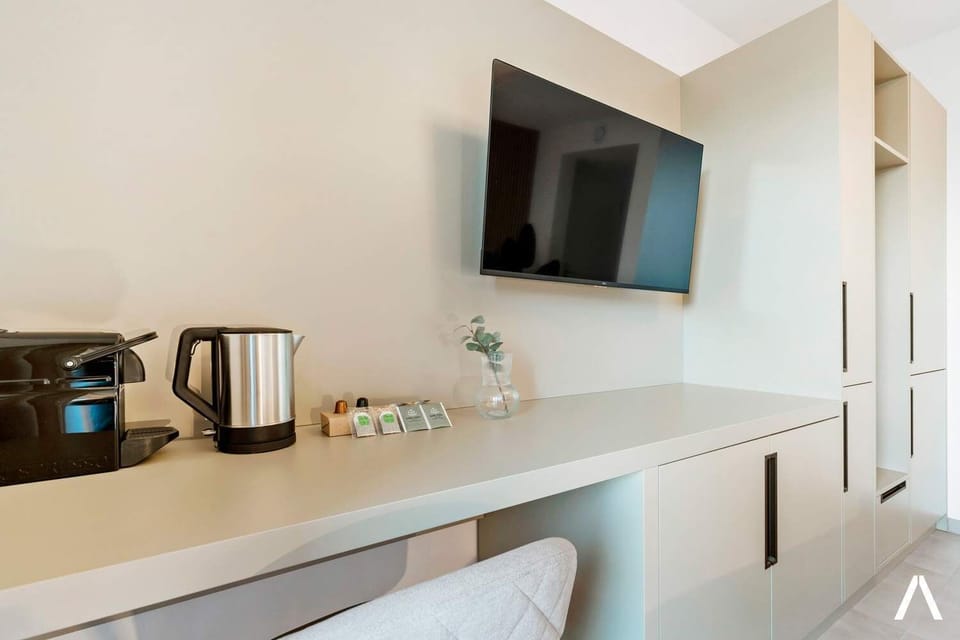 Functional Workspace and Entertainment Area – Wall-mounted TV, small desk, and a cozy chair create a perfect blend of comfort and productivity.