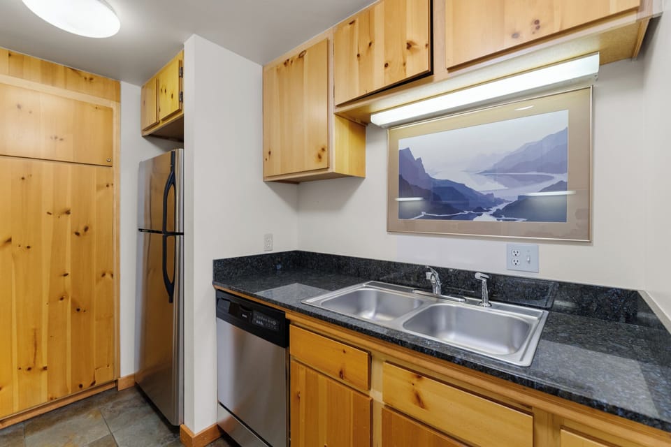 Full kitchen featuring stainless steel appliances and black granite countertops.
