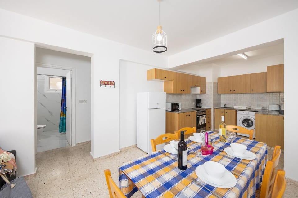 Open-plan living room with sofa, dining area, kitchen, A/C, WiFi internet, and satellite TV