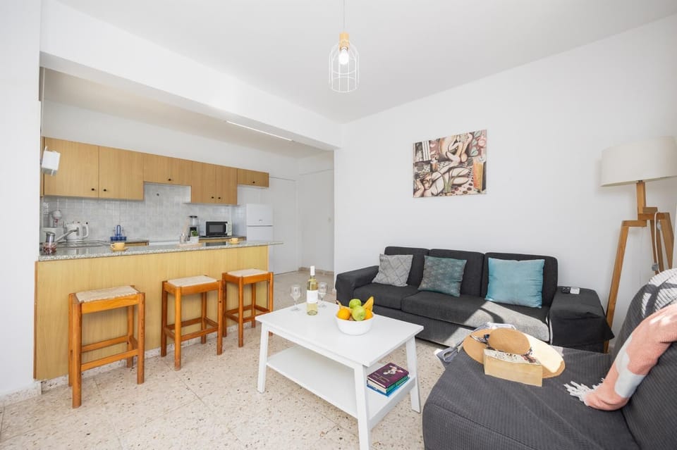 Open-plan living room with sofa, kitchen, A/C, WiFi internet, and satellite TV