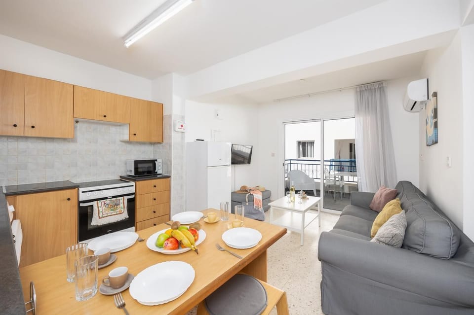 Open-plan living room with sofa, kitchen, A/C, WiFi internet, and satellite TV