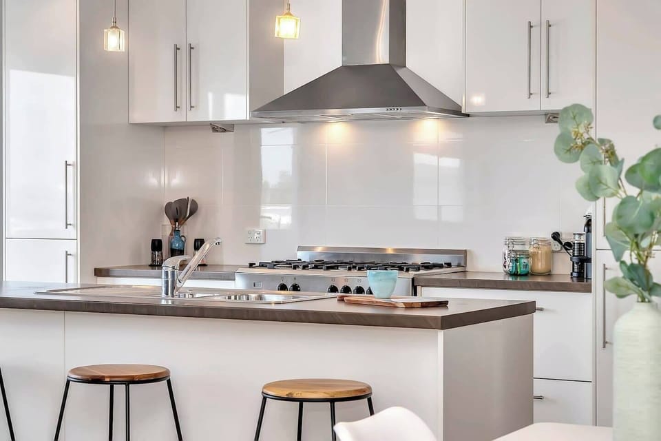 Modern kitchen with stainless steel appliances and access to the balcony for easy outdoor dining.
