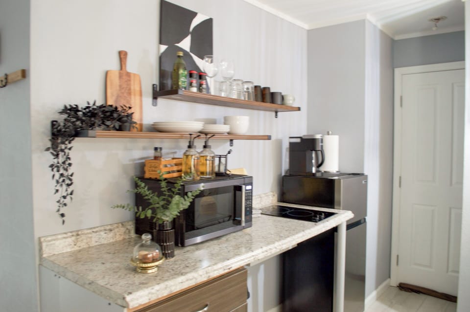 Spacious mini fridge, with a hot kettle and Keurig machine, the perfect microwave to warm up any left overs