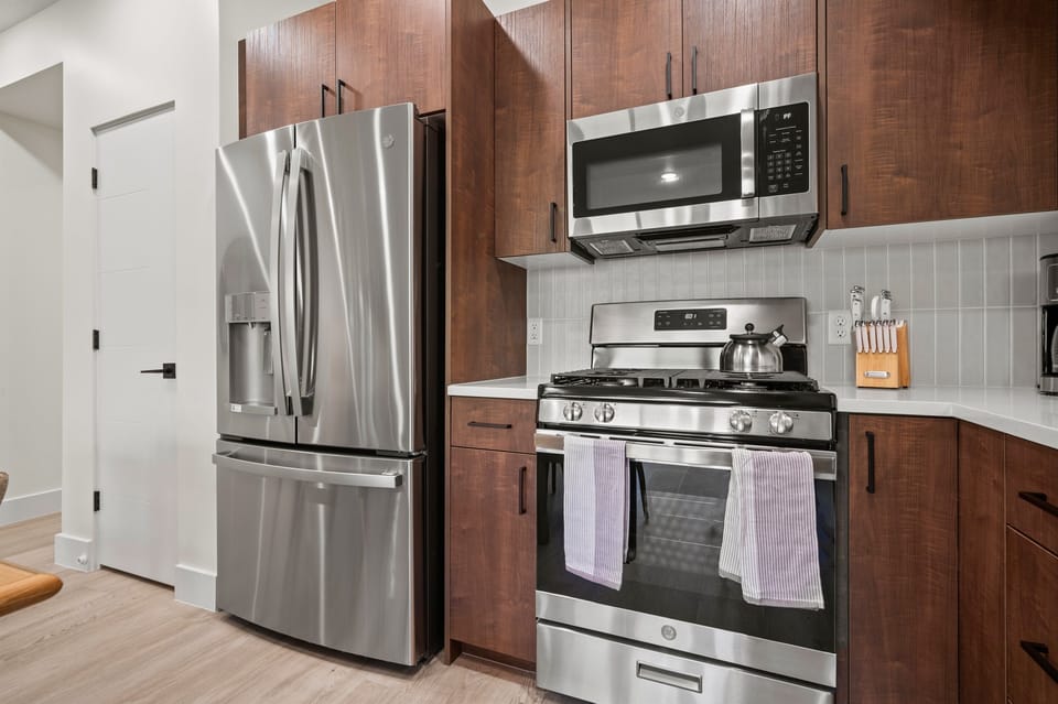 This well-equipped kitchen features a gas stove, fridge with ice maker, microwave, and other appliances for your convenience and culinary enjoyment.