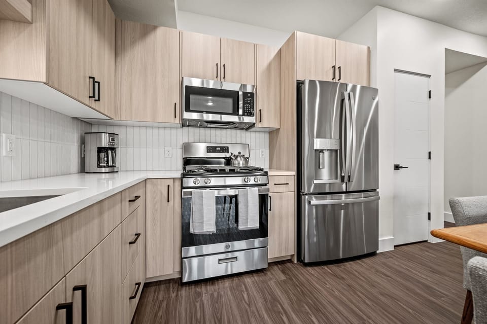 This well-equipped kitchen features a gas stove, fridge with ice maker, microwave, and other appliances for your convenience and culinary enjoyment.