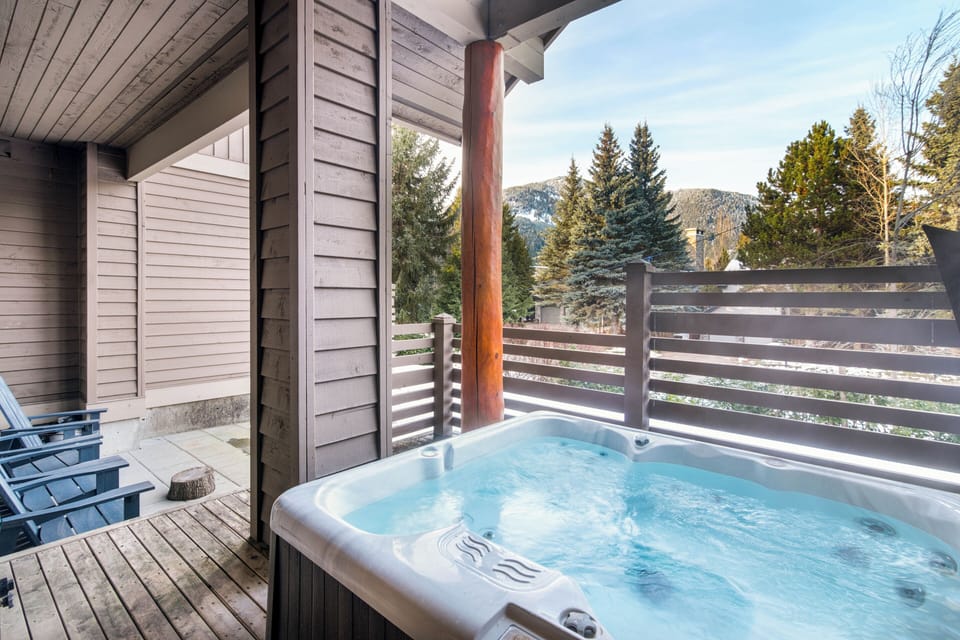Private patio with outdoor seating, hot tub, and mountain views. 
