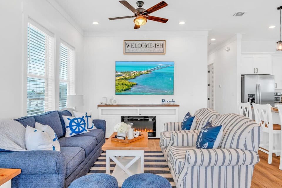 Stylish & Comfortable Living Room | Coastal Vibes Throughout Unwind in a sunlit space filled with soft textures, bold blues, and island décor — ideal for evenings i