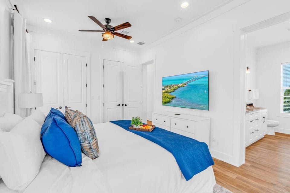 Master Bedroom Suite | Spacious Comfort + TV A calming escape after beach days, this stylish suite includes premium bedding, a flat-screen TV, and total privacy.