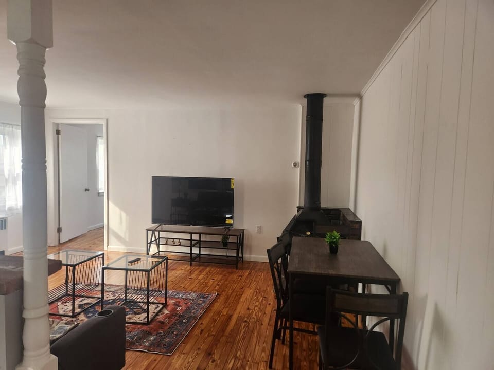 The living room comes furnished with essential pieces, including a comfortable sofa, a coffee table, TV stand, and dining table, providing immediate comfort upon move-in.
