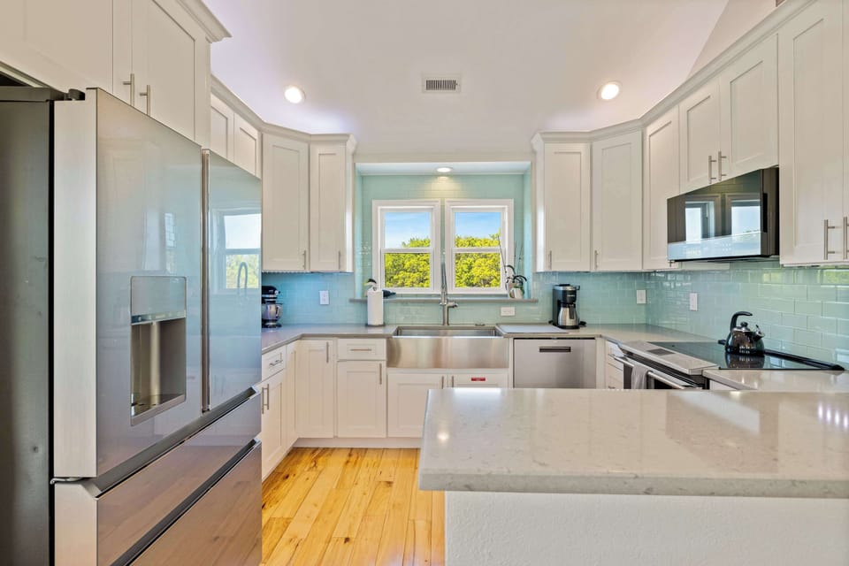 Bright White Kitchen w Stainless Steel Refrigerator, Microwave, Oven Range, Dishwasher, Sink, Cooking Utensils and Quartz Counters