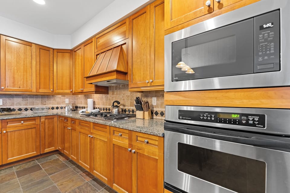 Your fully equipped kitchen features warm wood cabinets, granite counters, and stainless steel appliances for all your cooking needs.