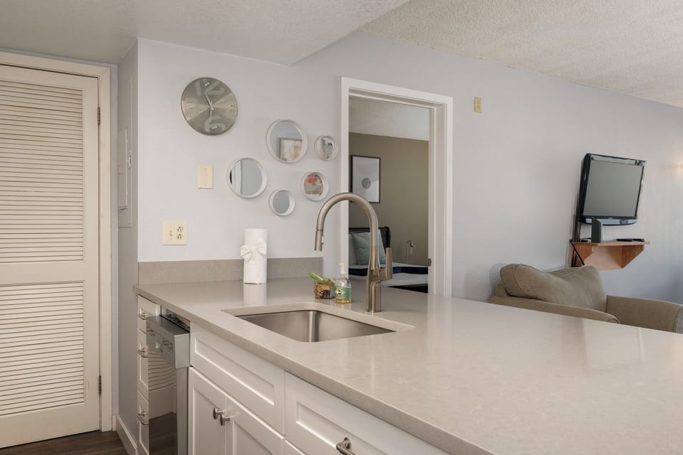 Your stylish kitchen at Summit Unit 1103 features pristine white countertops and modern appliances, creating the perfect space for preparing meals during your stay.