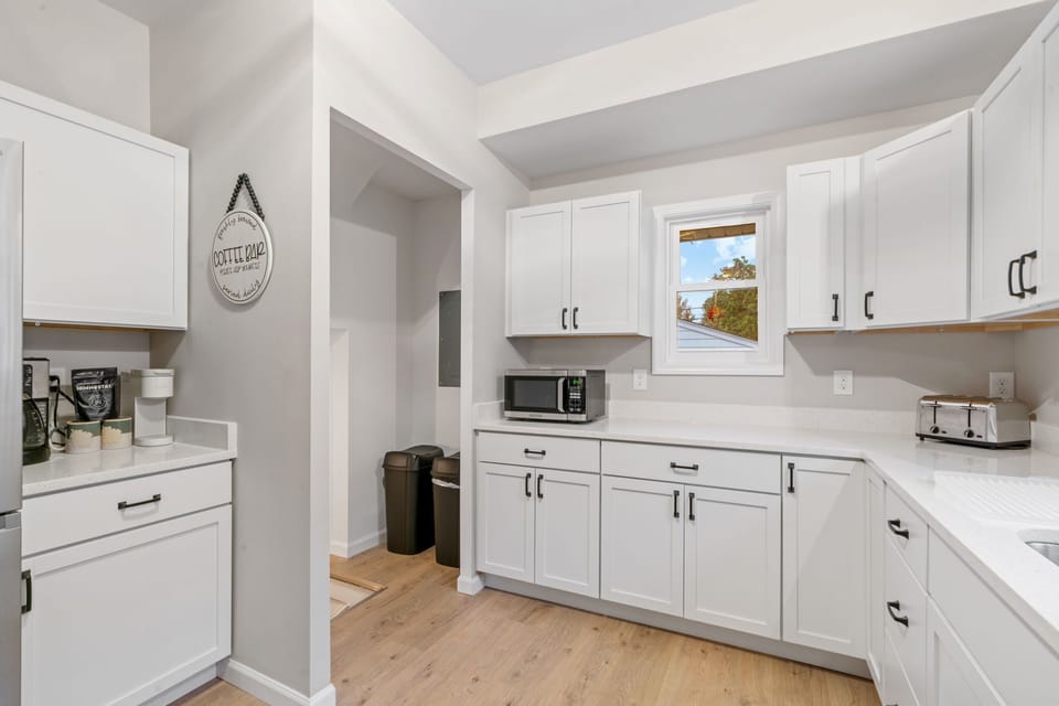 Your fully equipped kitchen features crisp white cabinets, modern appliances, and ample counter space for preparing memorable meals.