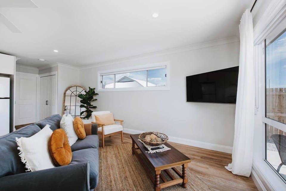 The living area is a comfortable space to relax with plush sofas and wall-mounted TV.