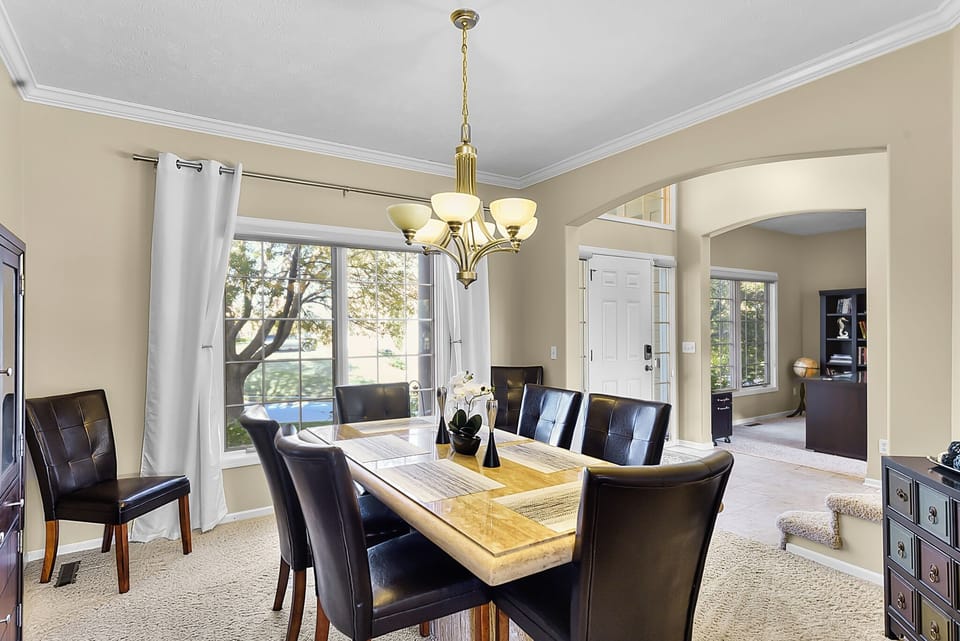 Gather around this elegant dining table where memorable meals await, bathed in natural light from expansive windows.