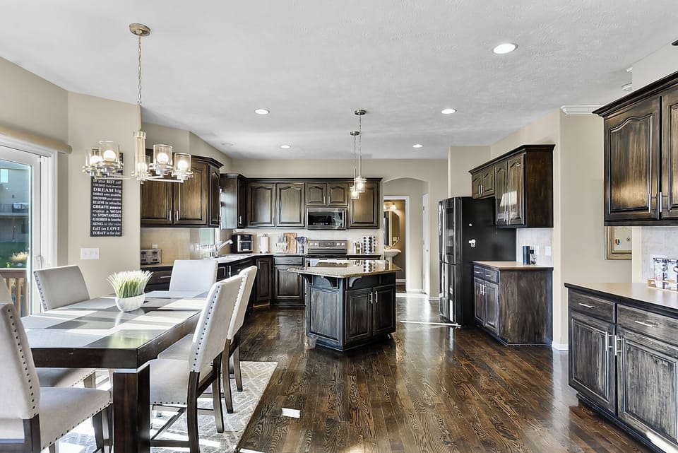 Your gourmet kitchen awaits with rich dark cabinetry, granite countertops, and a spacious island perfect for cooking and gathering.