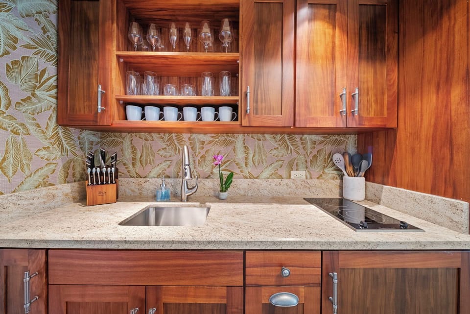 Island-inspired kitchenette with tropical backsplash and custom cabinetry, perfect for casual cooking.