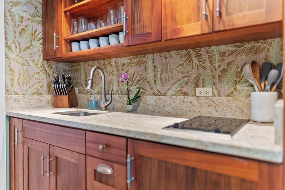 Chic kitchenette featuring natural wood finishes, tropical decor, and a cozy cooking space.