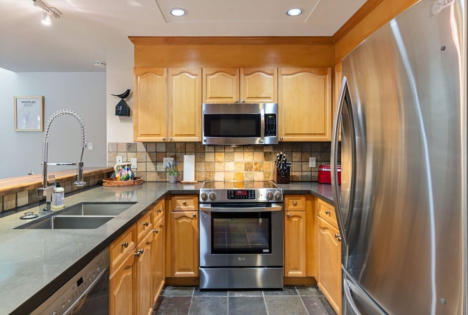The modern kitchen is fully equipped with stainless steel appliances and everything you need to cook at home.