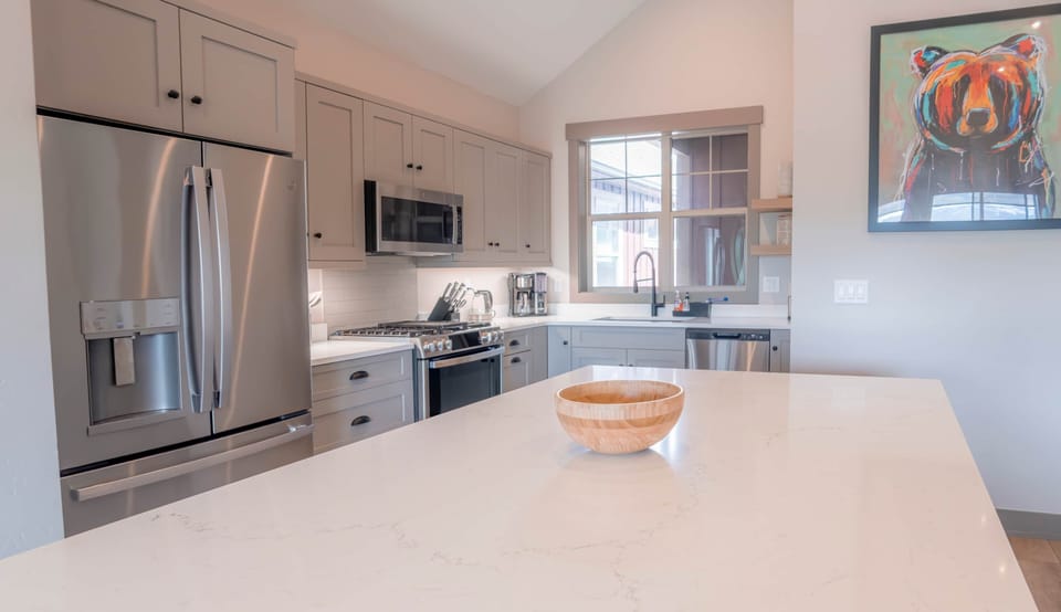 Fully equipped kitchen with modern appliances and a large, elegant island for gathering.