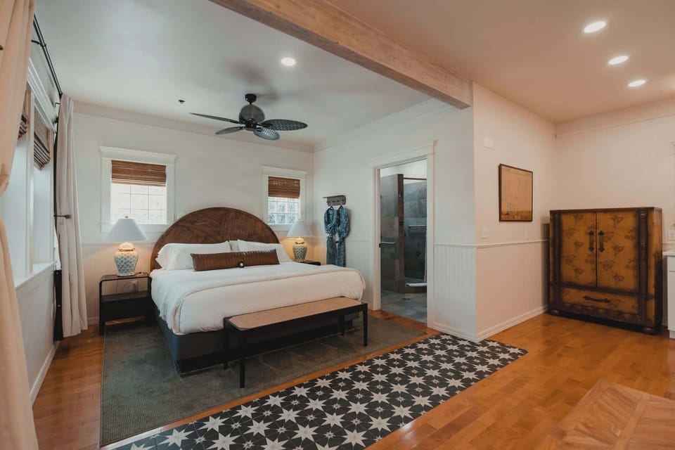 Spacious studio suite showcasing patterned tile walkway, king bed, and en-suite bathroom.