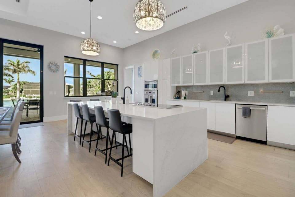 The waterfall island w/barstool seating defines the kitchen space; cookware, dinnerware, many kitchen tools & small electrical appliances are included