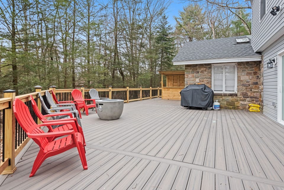 Expansive Outdoor Deck
Step outside and breathe in the fresh air on this spacious deck, complete with colorful Adirondack chairs, a grill, and serene wooded views, perfect for morning coffee or evening gatherings.