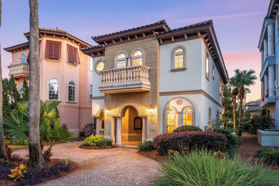 The stunning design aesthetic of Tuscan Charm with lush landscaping, arched windows, & circular driveway.