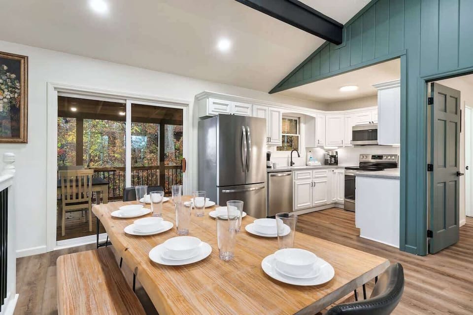 Modern kitchen and dining area with stainless steel appliances and a view of the outdoor deck.