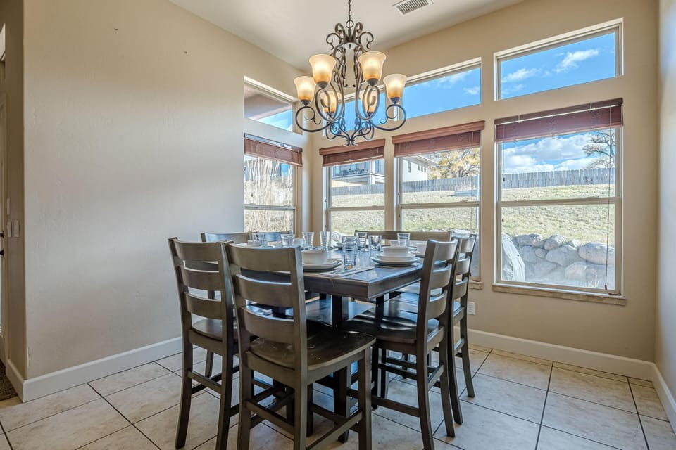 The wood dining table, comfortably seating up to eight, creates the perfect setting for family gatherings or intimate dinners.