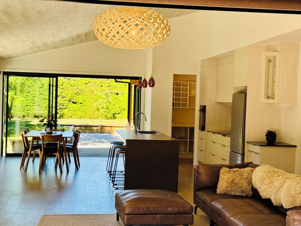 Two sets of stacking sliding doors bring the outside in from the dining table