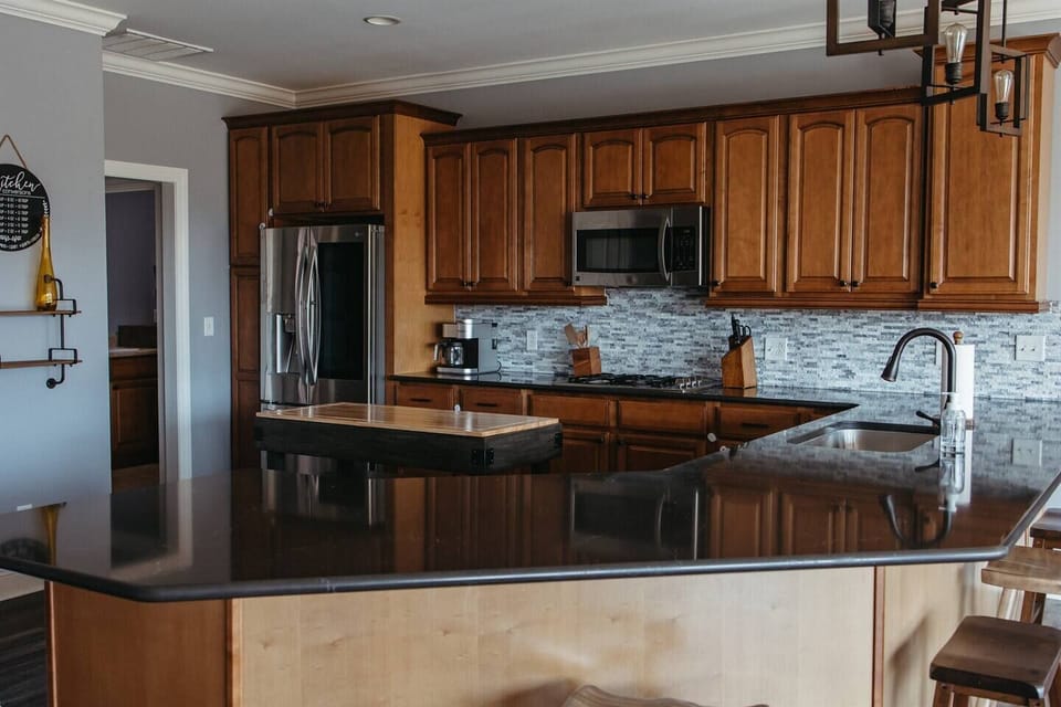 Wood cabinets and black counter tops in a kitchen.
